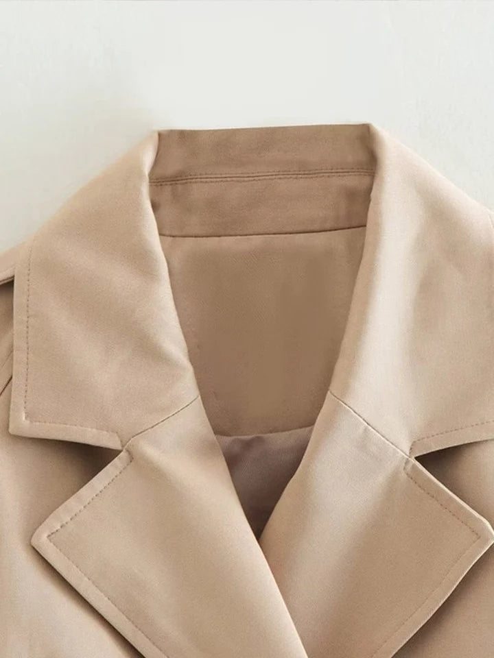 Trench coat corto beige para mujer con doble botonadura